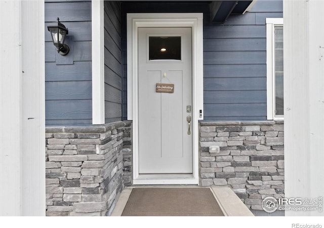 doorway to property with stone siding