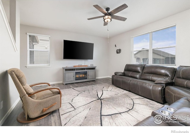 living room with a ceiling fan, a healthy amount of sunlight, baseboards, and wood finished floors