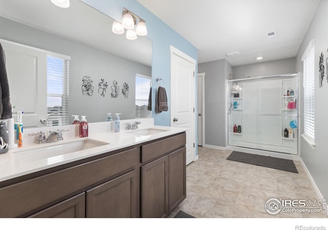 full bathroom featuring double vanity, a sink, visible vents, and a shower stall