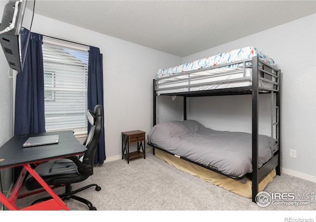 bedroom featuring light carpet and baseboards