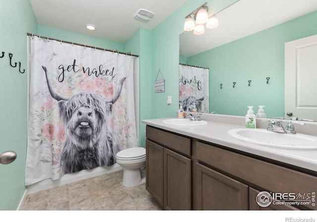 full bath featuring toilet, double vanity, a sink, and visible vents