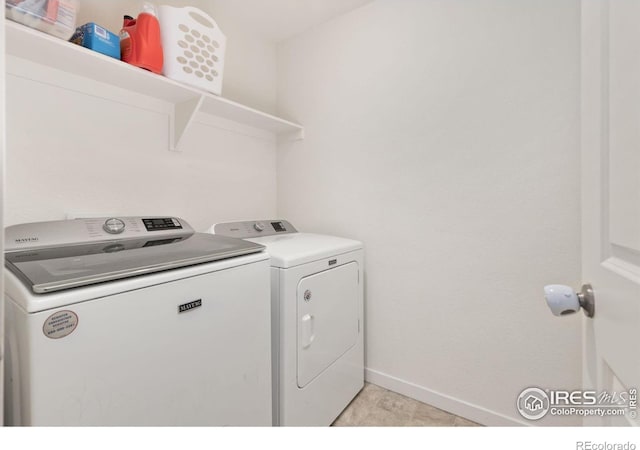 laundry room featuring laundry area, baseboards, and washing machine and clothes dryer