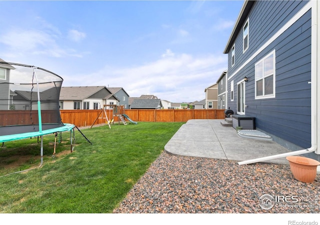 view of yard featuring a patio, a trampoline, a playground, and a residential view