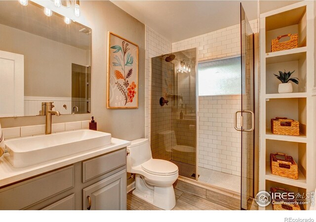 bathroom featuring a stall shower, vanity, and toilet