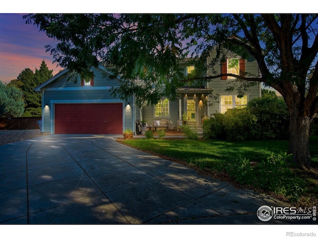 view of front of home with a garage, concrete driveway, and a front yard