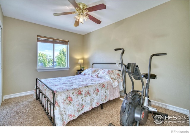 bedroom featuring light carpet, baseboards, and a ceiling fan