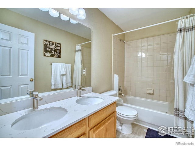 full bathroom featuring shower / bath combination with curtain, double vanity, a sink, and toilet