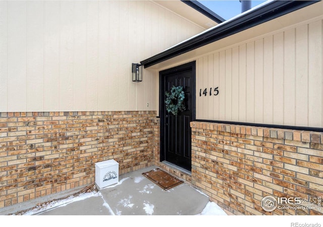 doorway to property with brick siding