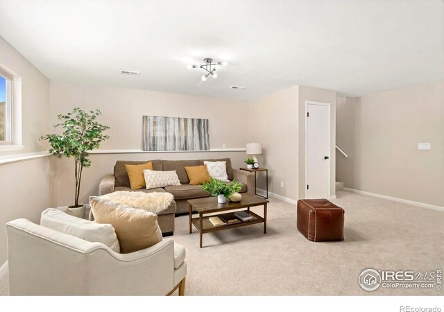 living room with carpet, visible vents, and baseboards