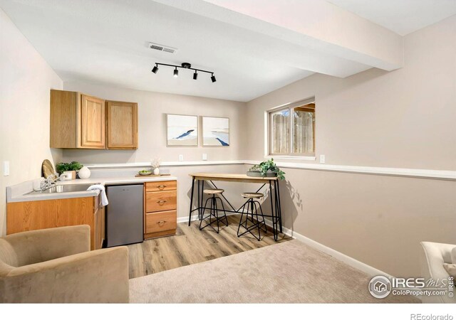 kitchen with baseboards, visible vents, light countertops, stainless steel dishwasher, and a sink