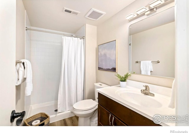 bathroom featuring toilet, a stall shower, visible vents, and vanity