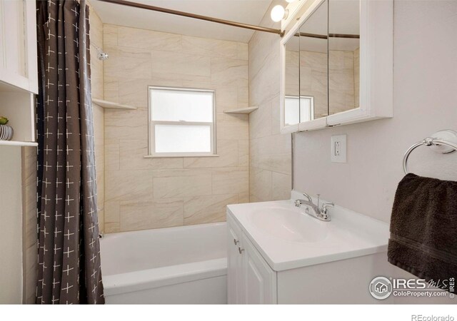 full bathroom featuring shower / bathtub combination with curtain and vanity