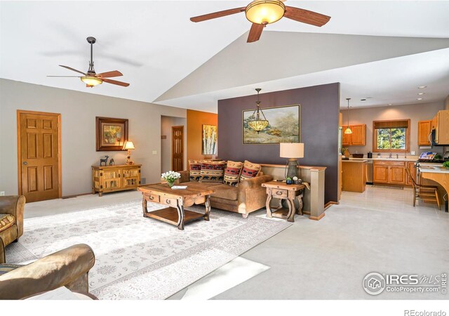 living room with vaulted ceiling, a ceiling fan, and light colored carpet