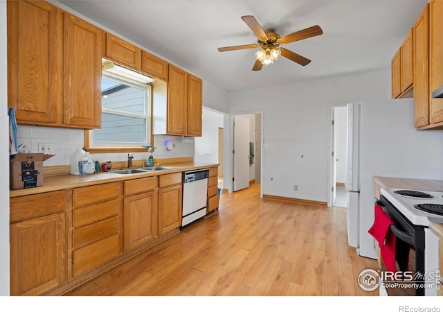 kitchen featuring light wood-style flooring, range with electric stovetop, a sink, light countertops, and dishwasher