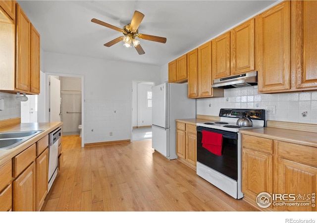 kitchen with electric stove, light countertops, freestanding refrigerator, and under cabinet range hood