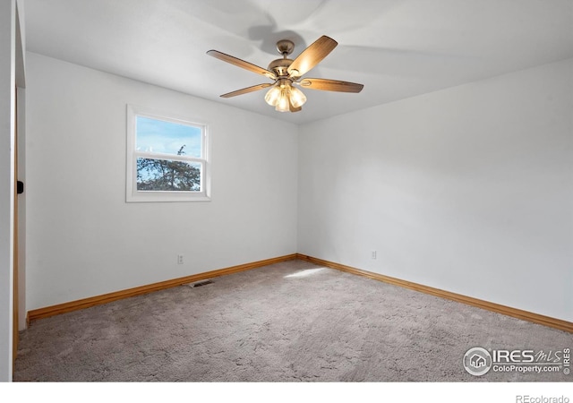 spare room featuring ceiling fan, carpet, visible vents, and baseboards