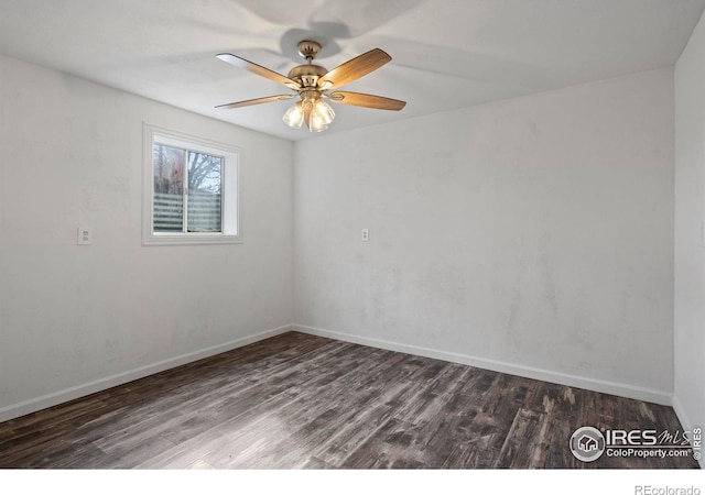 empty room featuring dark wood-style floors, a ceiling fan, and baseboards