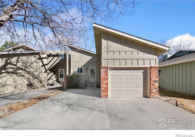 view of side of home featuring concrete driveway, brick siding, board and batten siding, and an attached garage