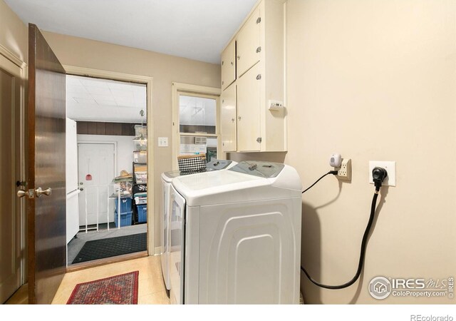 laundry room with independent washer and dryer and cabinet space