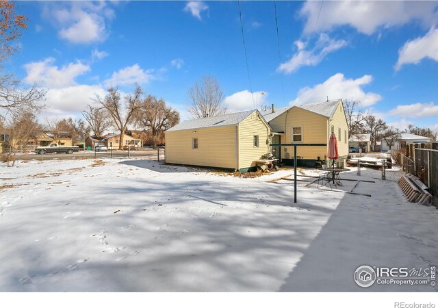 view of snowy exterior with a residential view and fence