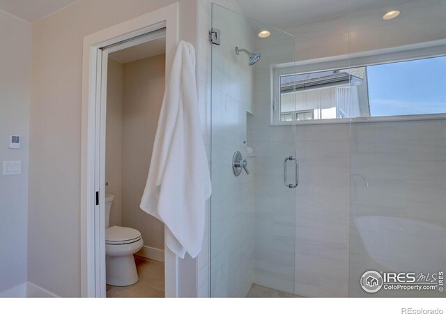 full bathroom featuring a stall shower and toilet