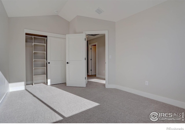 bedroom featuring light colored carpet, visible vents, baseboards, vaulted ceiling, and a closet
