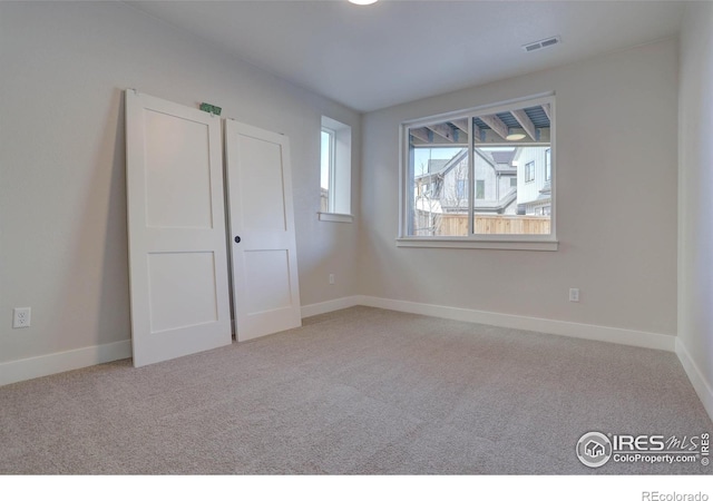 unfurnished bedroom featuring baseboards, visible vents, and carpet flooring