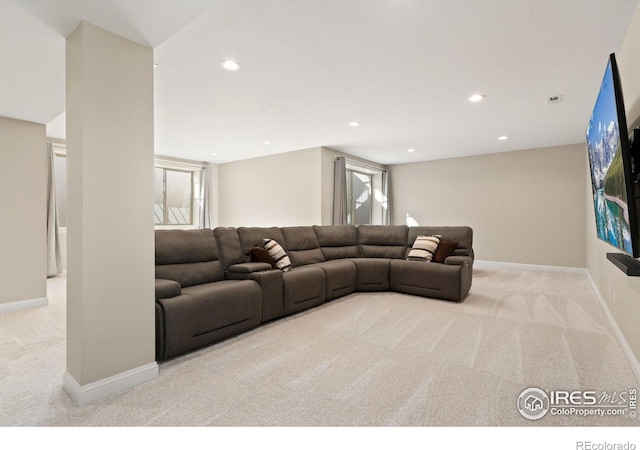 living room featuring recessed lighting, light colored carpet, and baseboards