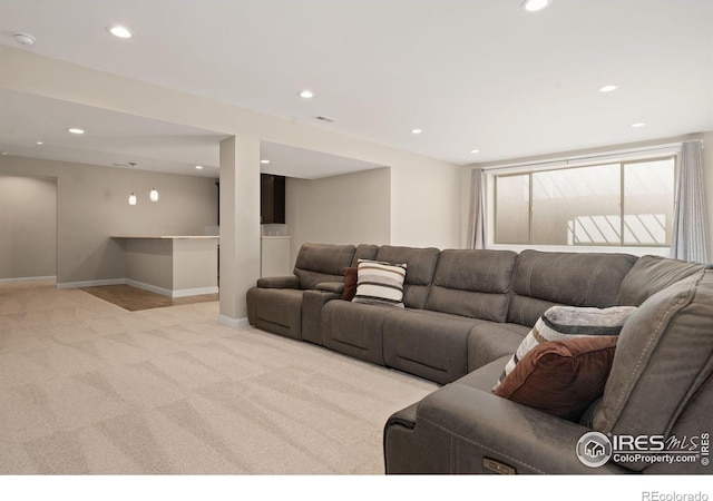 living room with recessed lighting, light colored carpet, and baseboards