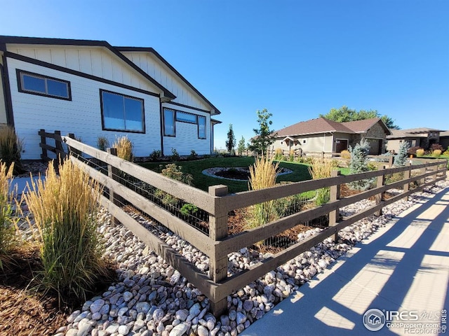 view of front of home with board and batten siding and a fenced front yard