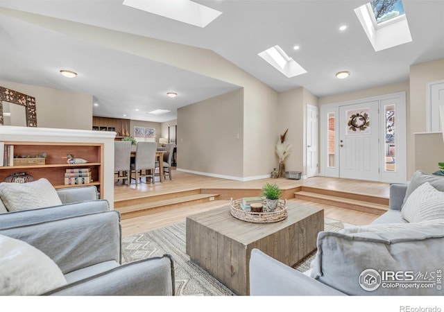 living room with vaulted ceiling, recessed lighting, light wood-type flooring, and baseboards