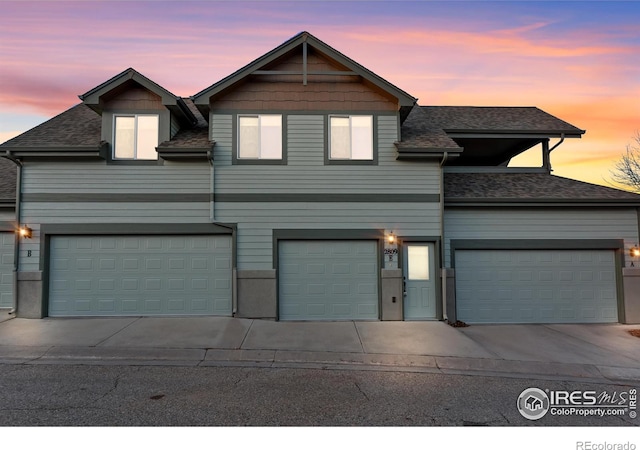 view of front facade featuring a garage, concrete driveway, a shingled roof, and an attached garage