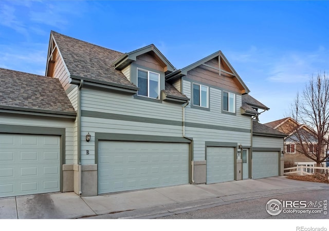 view of front of property with a garage and roof with shingles