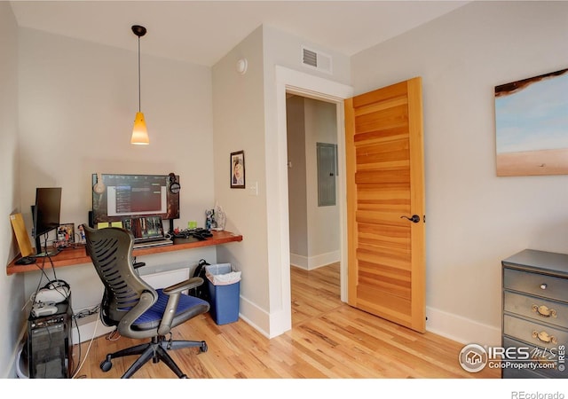 office space featuring electric panel, visible vents, baseboards, and wood finished floors