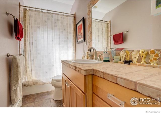 bathroom with toilet, vanity, stone tile flooring, and shower / bathtub combination with curtain