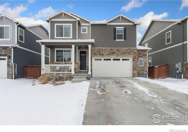 craftsman house featuring a garage, stone siding, a porch, and concrete driveway