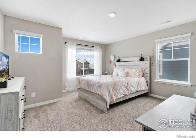 bedroom with light carpet, visible vents, and baseboards