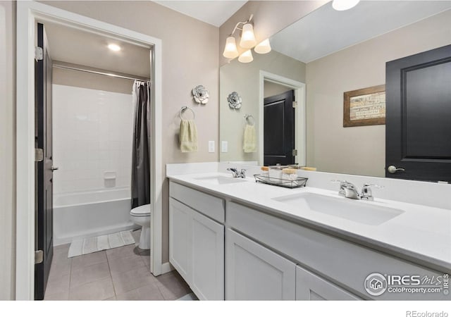 bathroom featuring toilet, shower / bath combination with curtain, a sink, and tile patterned floors