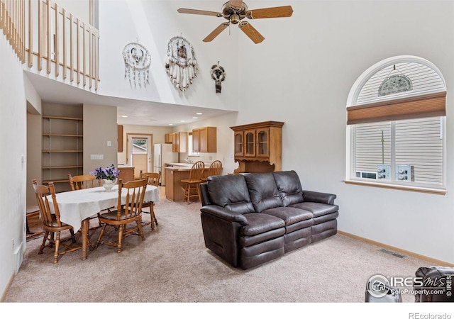2143 Meadow Ct, Longmont, CO 80501 - living area featuring light colored carpet, a high ceiling, a ceiling fan, and baseboards