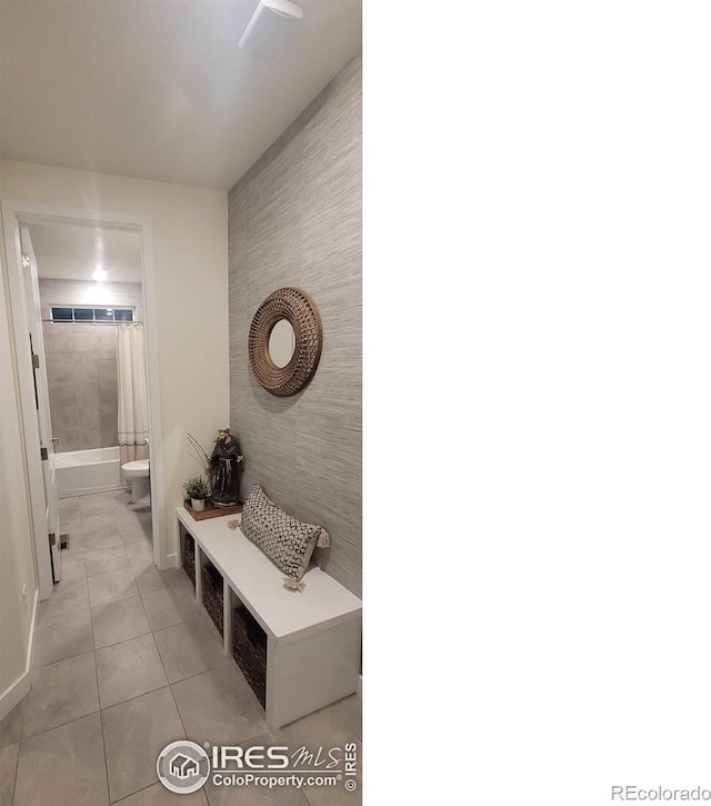 mudroom featuring an accent wall, tile walls, and light tile patterned flooring