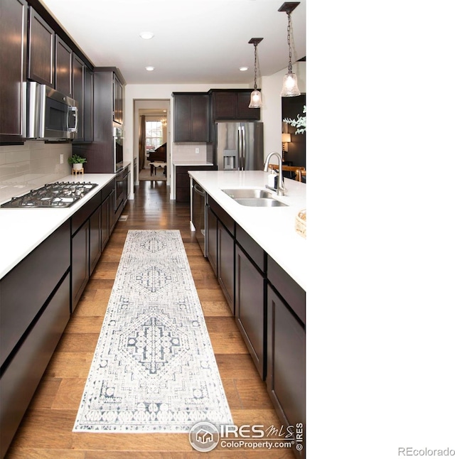 7086 Thunderview Dr, Timnath, CO 80547 - kitchen featuring stainless steel appliances, a sink, light countertops, tasteful backsplash, and recessed lighting