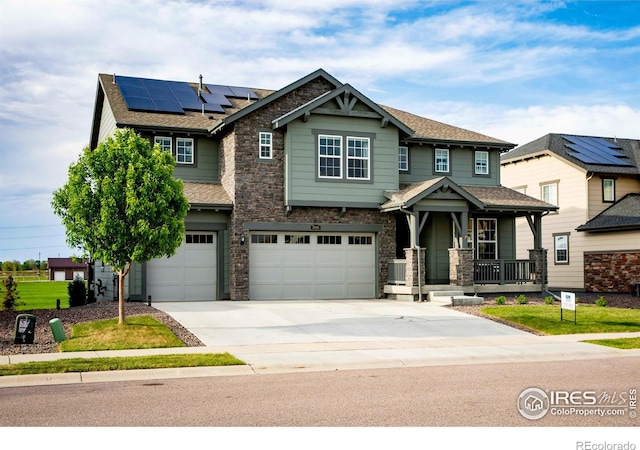 7086 Thunderview Dr, Timnath, CO 80547 - craftsman house featuring a porch, driveway, stone siding, solar panels, and an attached garage
