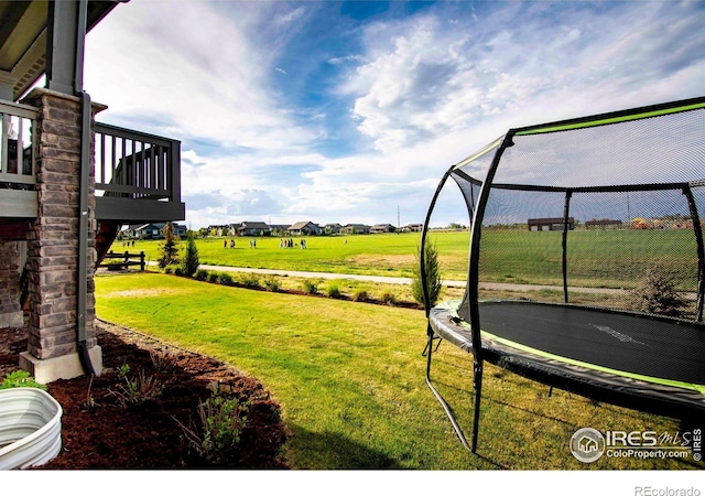 7086 Thunderview Dr, Timnath, CO 80547 - view of grassy yard with a trampoline