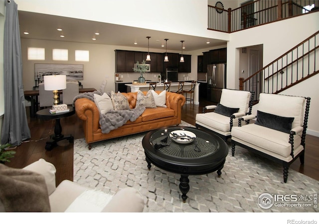7086 Thunderview Dr, Timnath, CO 80547 - living area with light wood-style floors, recessed lighting, stairway, and a towering ceiling