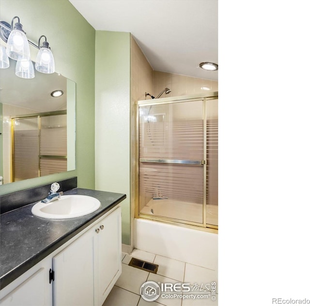 bathroom featuring visible vents, vanity, bath / shower combo with glass door, and tile patterned floors