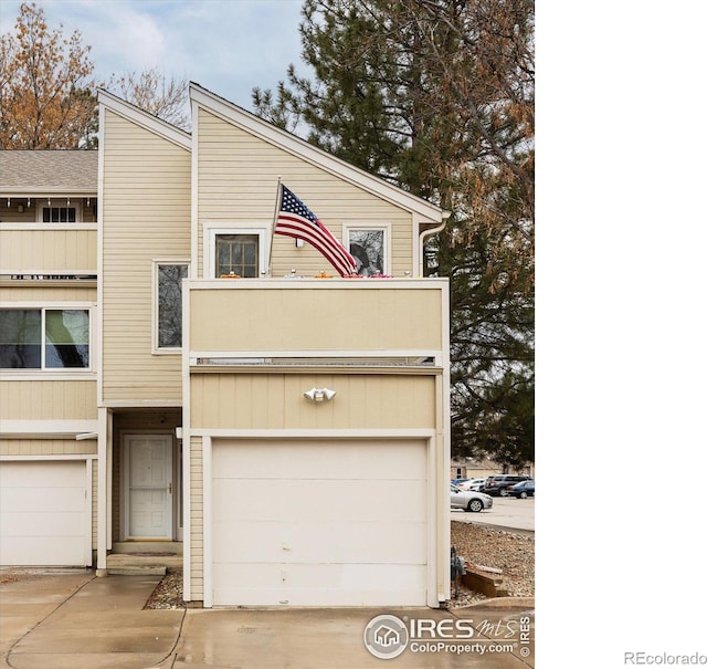 multi unit property featuring a garage and driveway