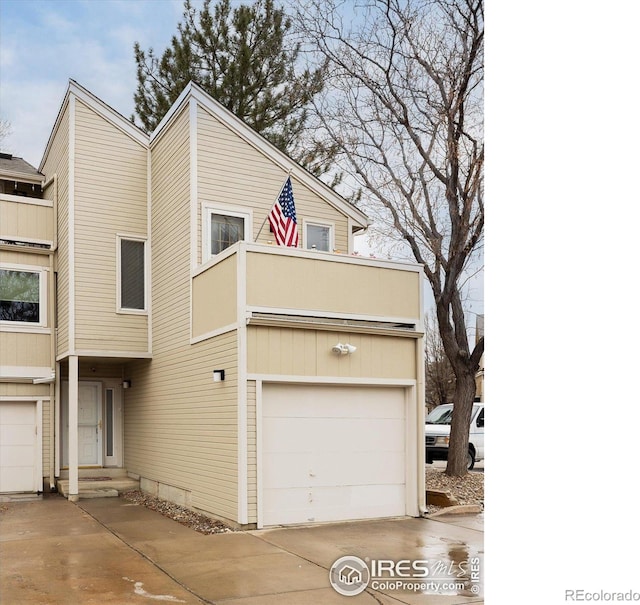 view of front of home featuring entry steps, driveway, a balcony, and an attached garage