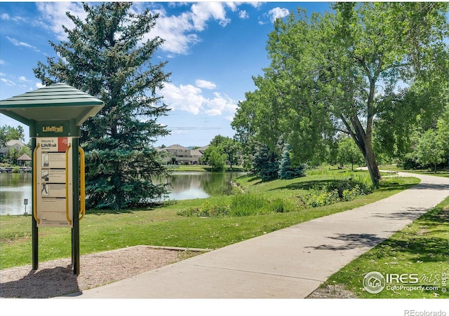 surrounding community featuring a water view and a yard