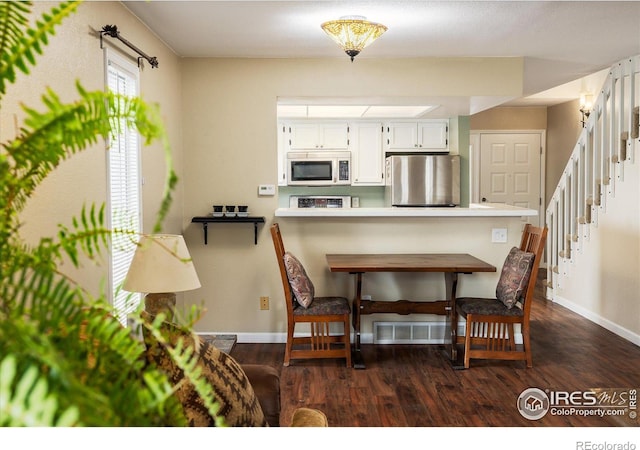 dining room with stairway, dark wood finished floors, and baseboards