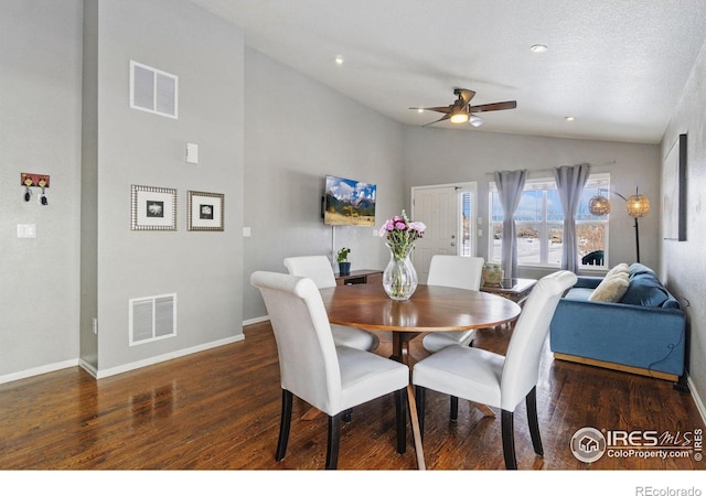 dining space featuring dark wood-style floors, lofted ceiling, and visible vents